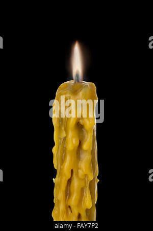 Brennen Sie Vintage Kirche Kerze Wachs Nahaufnahme auf einem brillanten schwarzen Hintergrund. Stockfoto