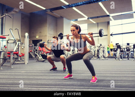 junger Mann und Frau mit Langhantel im Fitness-Studio trainieren Stockfoto