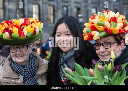 Niederlande, Amsterdam, Start Tulpe Saison. Dam-Platz. Tag der nationalen Tulpe. Zwei Damen mit Tulpe Hüte und touristischen Stockfoto