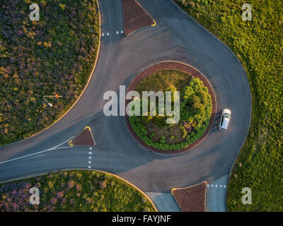 Aerial View-Single Auto in einen Kreisverkehr, Sommer, Reykjavik, Island. Bild aufgenommen mit einer Drohne. Stockfoto