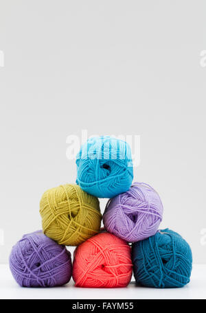 Colourful and varied balls  of wool or yarn  stacked up against a white background. Stockfoto
