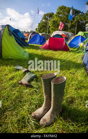 Ein paar schlammige Gummistiefel auf einem britischen Musik-Festival-Campingplatz. Geringe Schärfentiefe mit selektiven Fokus auf die Stiefel. Stockfoto