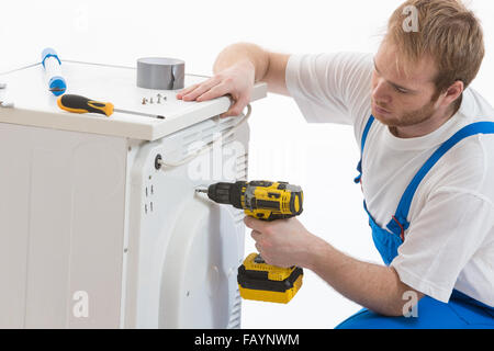 Tecnician Befestigung einer Waschmaschine Stockfoto