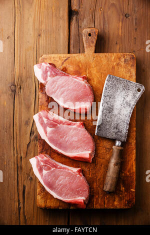 Roh frischen rohem Fleisch Schweinesteak auf Knochen auf Schneidblock chopping Board auf hölzernen Hintergrund Stockfoto
