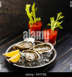 Ausgelöster Geldbußen de Claire Austern und Bloody Mary cocktail auf dunklem Hintergrund Stockfoto