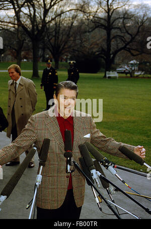 Washington, DC. , USA, 27. Dezember 1984 Präsident Ronald Reagan spricht mit Reportern vor dem südlichen Portikus-Eingang, wie er und First Lady Nancy Reagan darauf vorbereiten, Marine One board für Flug nach Andrews AFB für Reise nach Kalifornien.  Bildnachweis: Mark Reinstein Stockfoto