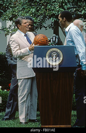 Washington, DC, USA, 13. Juni 1984 Präsident Ronald Reagan trifft mit den Boston Celtics, die National Basketball Association World Champions im Rosengarten. Coach Red Auerbach präsentiert ihn mit einer Team-Jacke.  Bildnachweis: Mark Reinstein Stockfoto