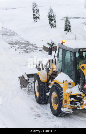 Traktor Schneeschaufeln auf der Straße. Stockfoto