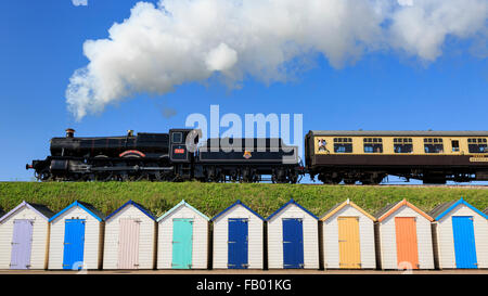 7827 Hols Lydham Manor einen Zug vorbei an den Strandhütten der Goodrington Sand, Paignton, Devon, an einem herrlichen Sommertag Stockfoto