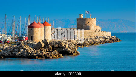 Die Burg und die alten Windmühlen am Eingang zum Hafen von Mandraki in Rhodos, Griechenland Stockfoto