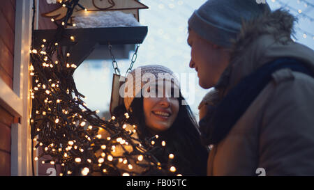 Junges Paar viel Spaß mit Weihnachtsbeleuchtung bei Spaziergängen auf dem Weihnachtsmarkt Stockfoto