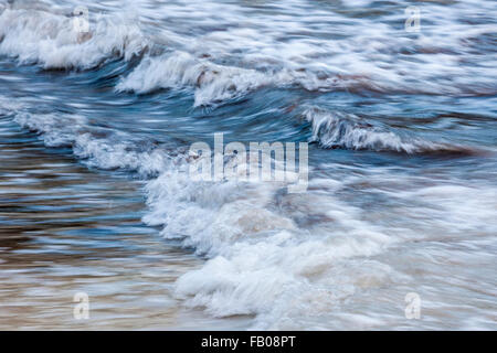 Schäumende Meereswellen brechen im flachen Wasser, in der Kamera Bewegungsunschärfe. Stockfoto