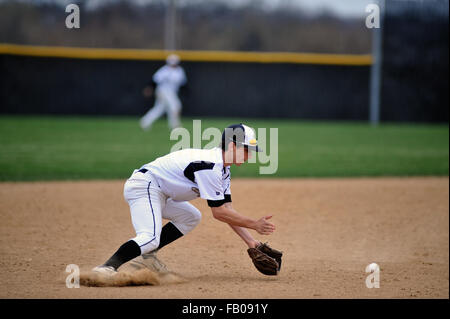 Ein High School shortstop Pflanzen seine Füße nach Segelfliegen zu seiner Rechten eine Kugel zu Feld und bevor die erste Basis zu werfen. USA. Stockfoto