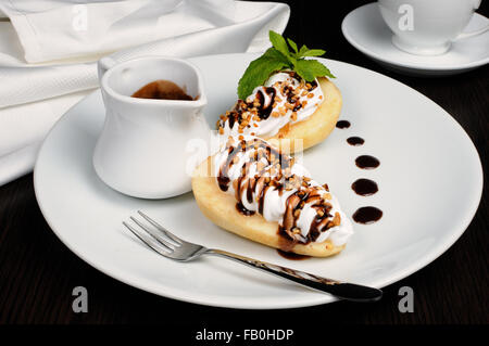 Birnen mit gepeitschter Creme bestreut Nüssen, Mandeln und Schokolade Stockfoto