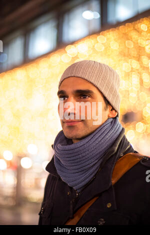 Junger Mann im Freien mit Weihnachtsdekoration Stockfoto