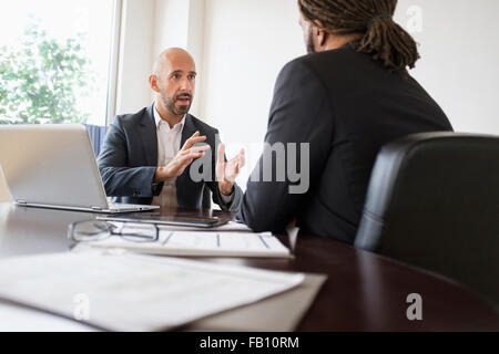 Zwei Geschäftsleute mit Diskussion am Schreibtisch im Büro Stockfoto