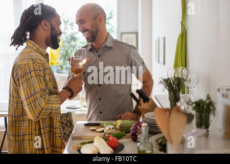 Smiley homosexuelles Paar Weintrinken in Küche Stockfoto