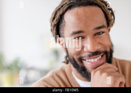 Porträt von Smiley junger Mann mit Hand am Kinn Stockfoto