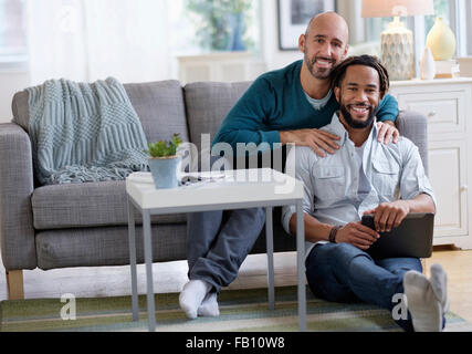 Mann massiert Freund vom Sofa im Wohnzimmer Stockfoto