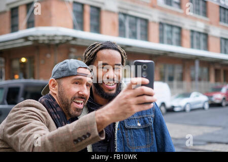 Smiley homosexuelle Paare nehmen Selfie mit Smartphone in der Straße Stockfoto