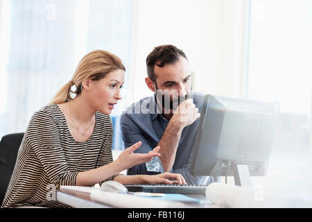 Mann und Frau, die am Computer im Büro Stockfoto