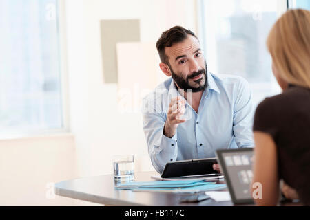Mann und Frau im Gespräch im Büro Stockfoto