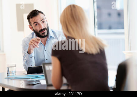 Mann und Frau im Gespräch im Büro Stockfoto