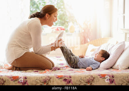 Mutter mit Sohn (2-3) auf Bett spielen Stockfoto