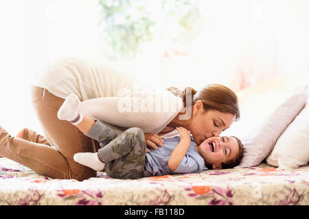 Mutter mit Sohn (2-3) auf Bett spielen Stockfoto