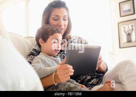 Mutter mit Sohn am Sofa (2-3) lesen Stockfoto