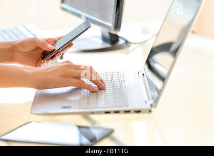 Business Frau SMS und auf Laptop-Tastatur eingeben Stockfoto