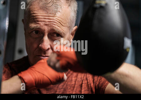 Mann im Health Club schlagen Beinsack Stockfoto