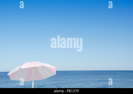 Sonnenschirm gegen blaue Seestück Stockfoto