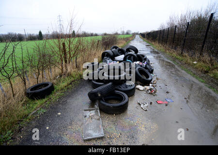 Flytipped Müll abgeladen auf einem Feldweg Straße. Stockfoto