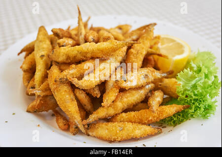 Kleine gebratene Fische, eine kleine Schüssel mit frittierten Sardellen mit Zitronenscheiben. Dies würde als Vorspeise oder Tapas in Spanien serviert werden. Stockfoto