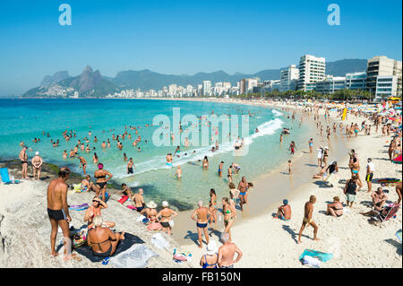 RIO DE JANEIRO, Brasilien - 8. Februar 2015: Beachgoers nutzen ruhige See am Arpoador Ende der Strand von Ipanema. Stockfoto