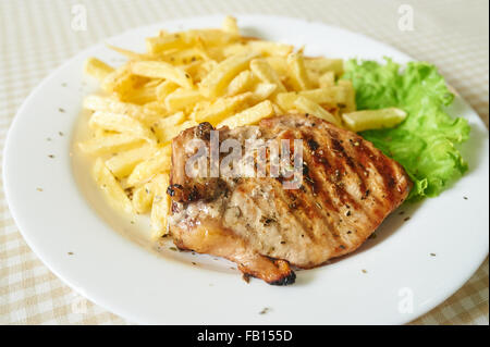 Hühnerfleisch mit Pommes Frites und Salat Stockfoto