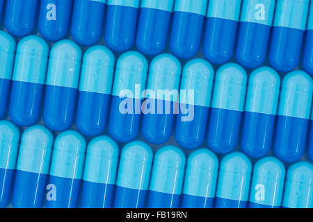 Nahaufnahme der Pillen - Kapselform aus Gelatine. Blaue Pillen - mögliche Metapher für NHS / National Health Service. Die Übernahme von US-Pharmaunternehmen. Stockfoto