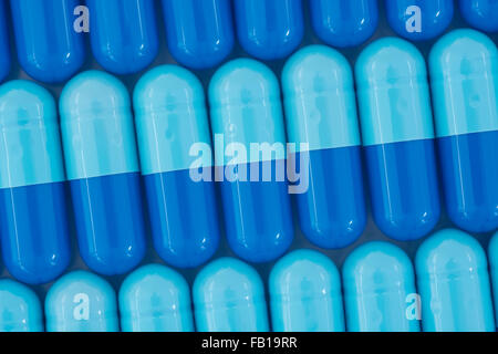 Nahaufnahme der Pillen - Kapselform aus Gelatine. Blaue Pillen - mögliche Metapher für NHS / National Health Service. Die Übernahme von US-Pharmaunternehmen. Stockfoto