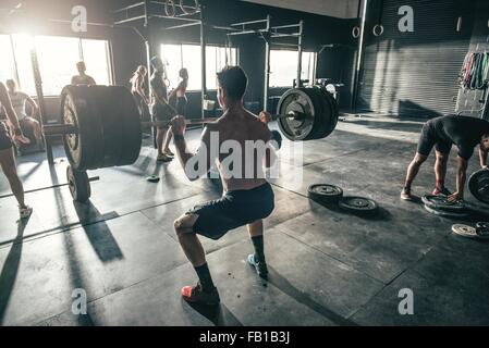 Mann mit Langhantel im Fitness-Studio trainieren Stockfoto