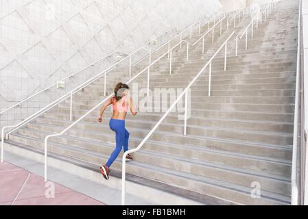 Rückansicht des junge Frau tragen Sportbekleidung Treppe hinauf laufen Stockfoto