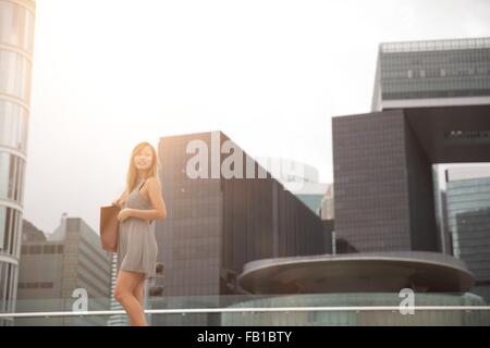 Junge Frau, die neben Hafen, Hong Kong, China Stockfoto