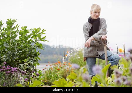 Porträt von Mitte Erwachsene Frau Graben im Bio-Garten Stockfoto