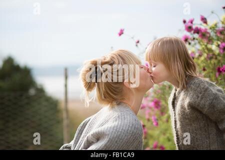 Mutter küssen Sohn im Bio-Garten Stockfoto