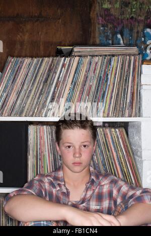 Teenager sitzen vor Vinyl Plattensammlung Blick in die Kamera Stockfoto
