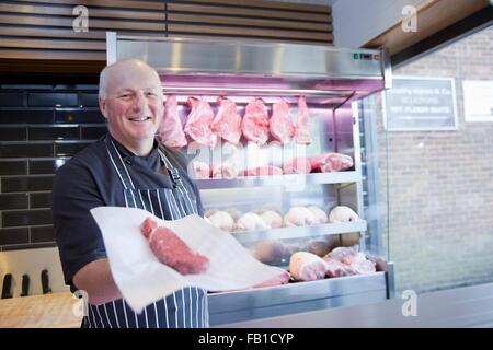 Porträt von Metzger holding Steak in Metzger-shop Stockfoto