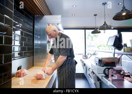 Reife Metzger, die Zubereitung von Fleisch in Metzger-shop Stockfoto