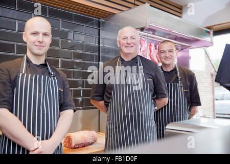 Porträt von drei männlichen Fleischer Metzger Shop Stockfoto