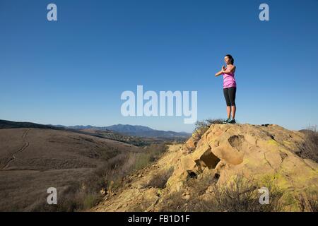 Frau praktizieren Yoga auf Hügel, Thousand Oaks, Kalifornien, USA Stockfoto