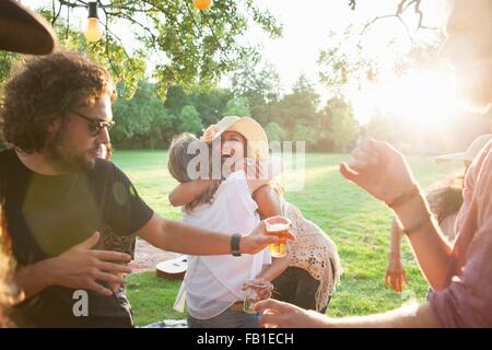 Partei, die Erwachsenen Freunden ankommen im Park bei Sonnenuntergang Stockfoto